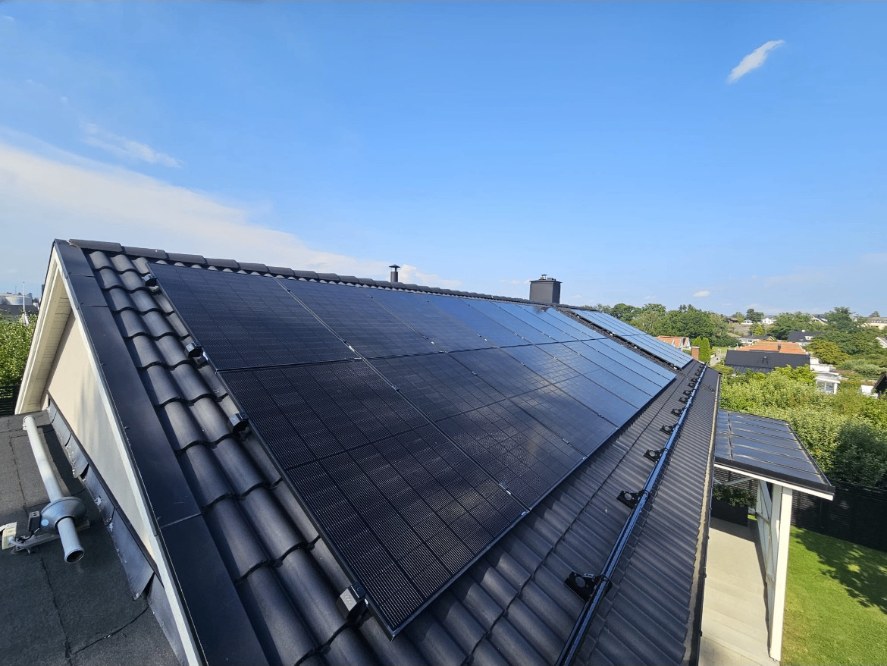 Svarta solcellspaneler i två rader på ett mörkt tegeltak på en villa i Lindö i Norrköping